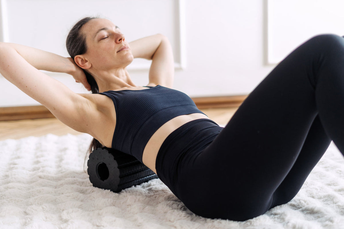 femme pratiquant la récupération musculaire sur un rouleau Image