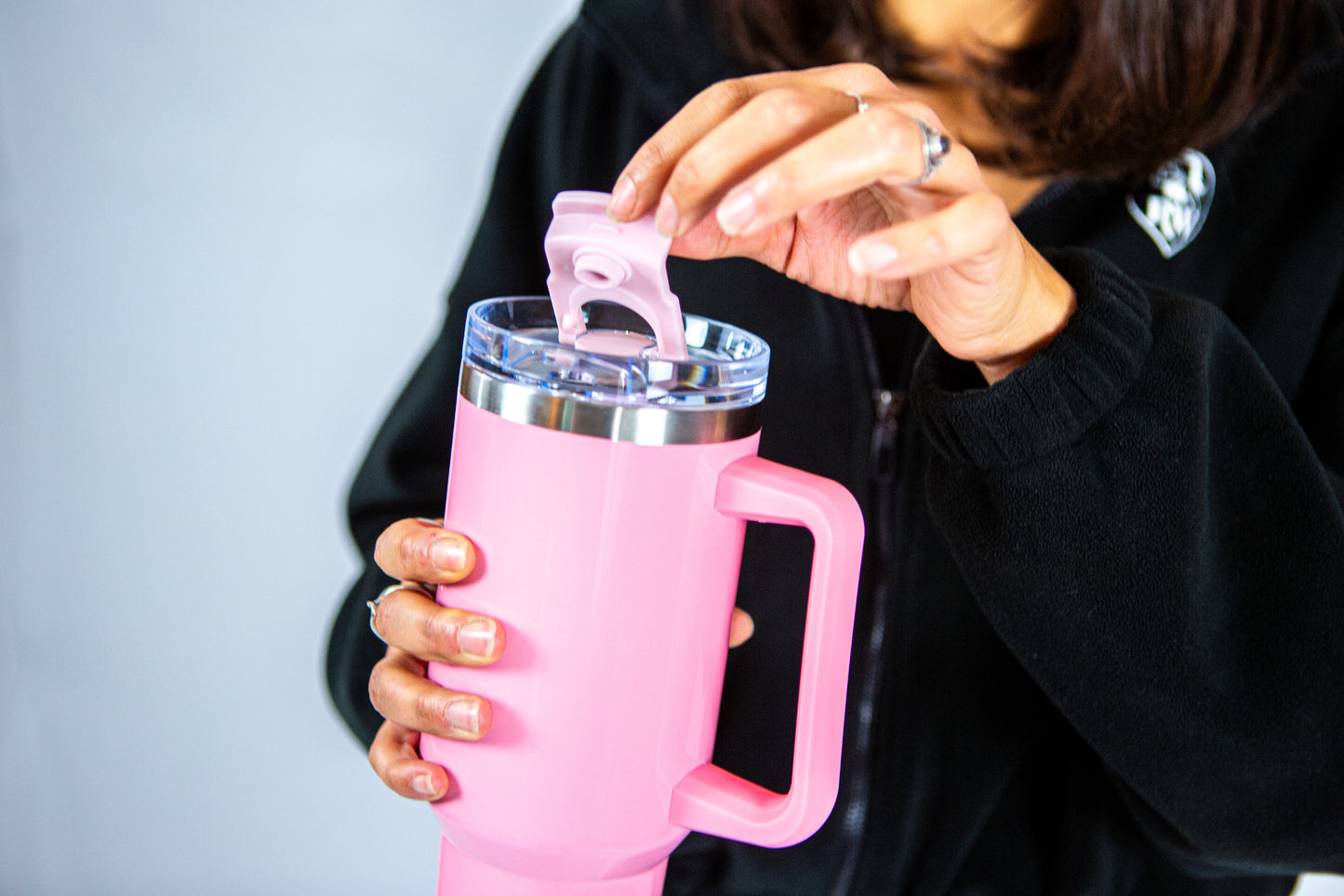 femme tenant la gourde rose reveal wear et montrant le couvercle