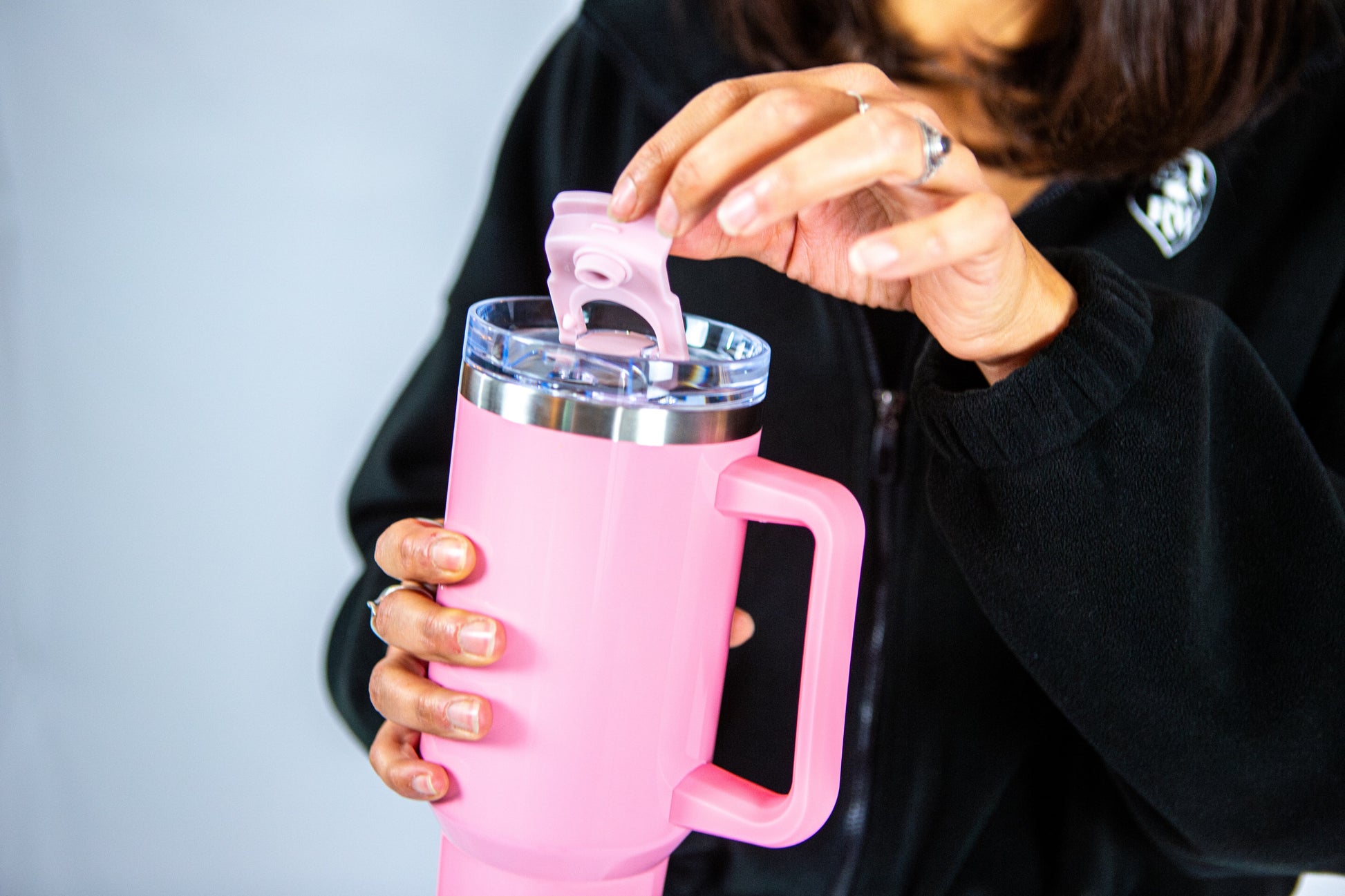 femme tenant la gourde rose reveal wear et montrant le couvercle