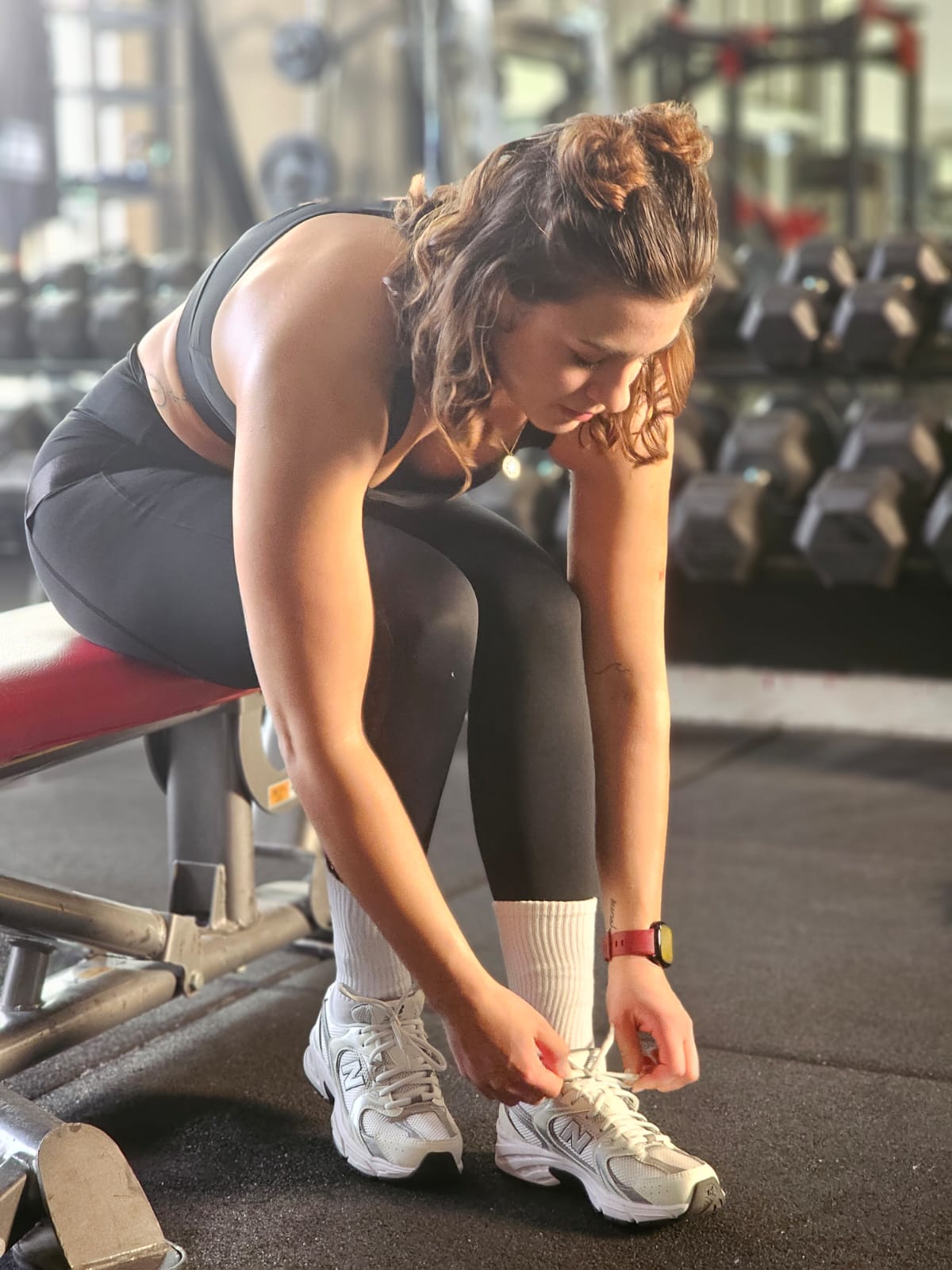 femme en tenue reveal wear noir avec chaussette blanche reveal wear mettant ses baskets