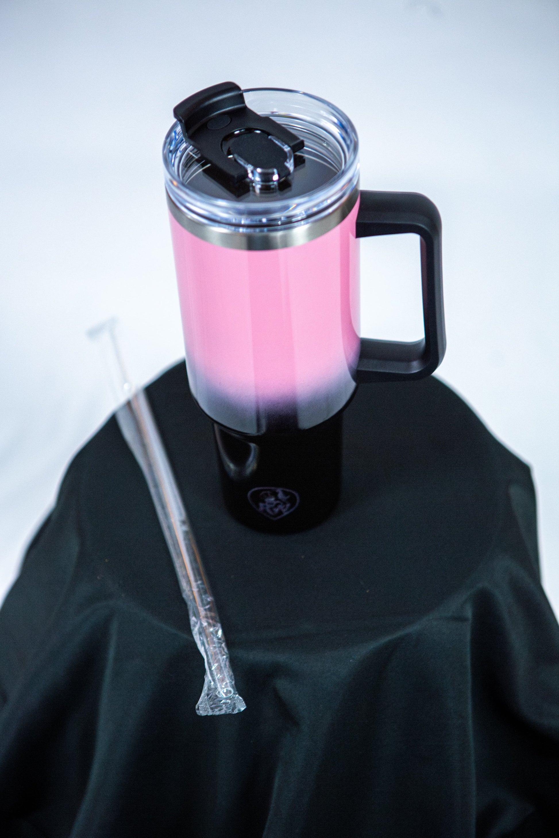 gourde reveal wear rose et noir avec la paille sur une table noir