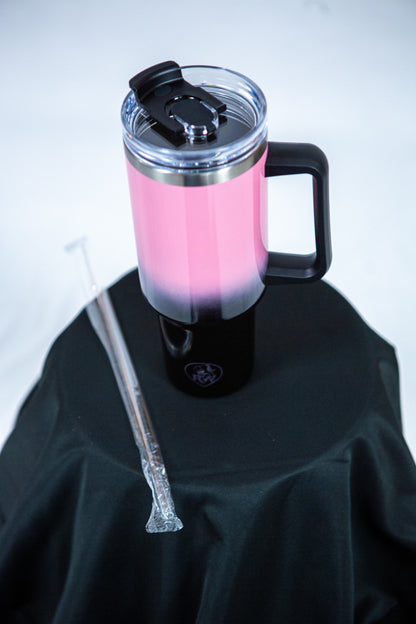 gourde reveal wear rose et noir avec la paille sur une table noir