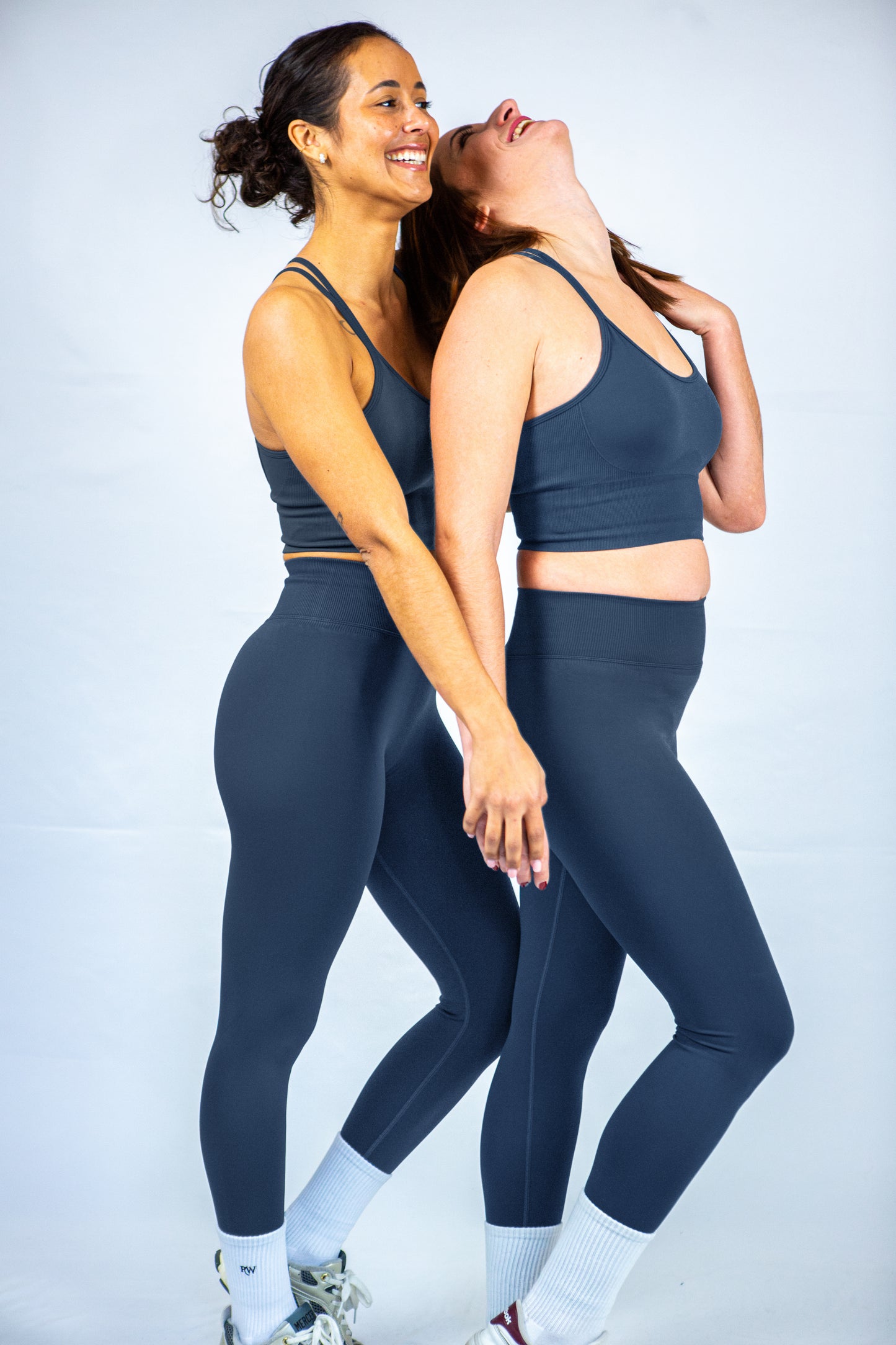 offre jumelle tenue de sport reveal wear vert foncé sur deux femmes de profil rigolant