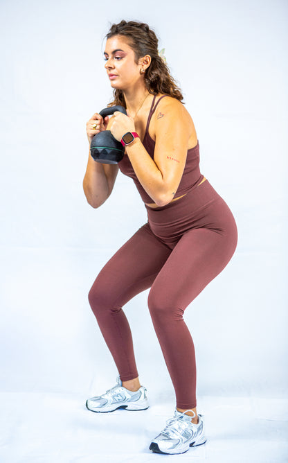 femme en tenue reveal wear cacao avec un poids libre dans les mains s'apprêtant à faire un squat